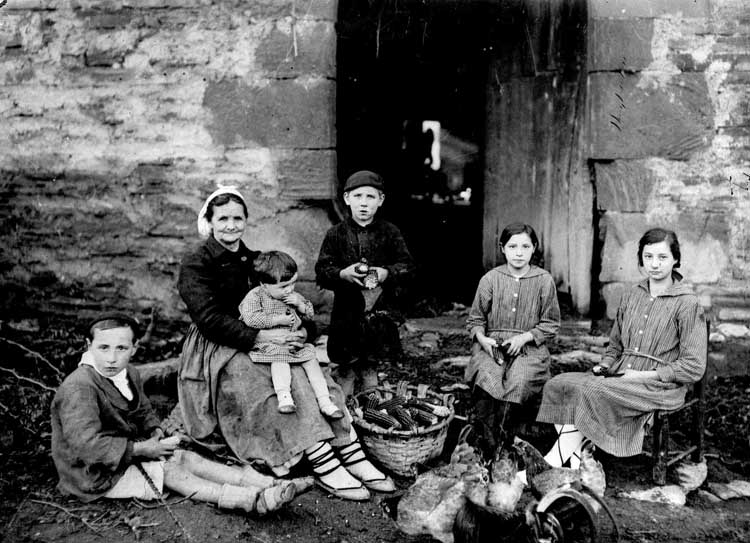 Foto antigua de familia en un caserío después de la recogida de mazorcas